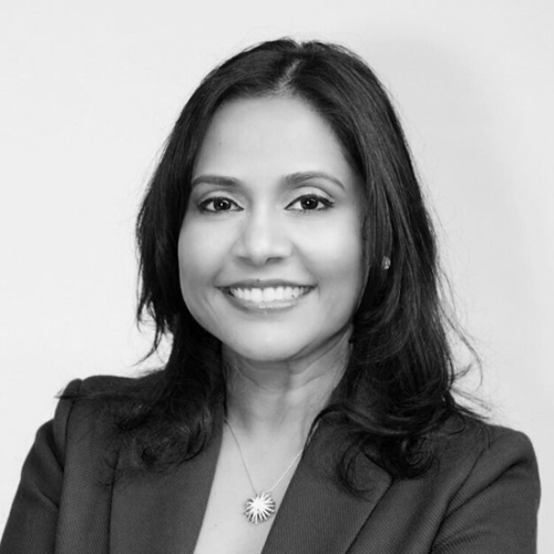 Woman with dark hair and jacket smilling.